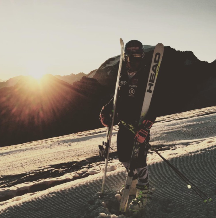 Carrying skis at sunset